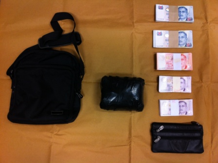 Black bundle containing heroin and cash seized on 18 Jan 2012