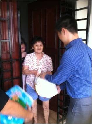 A CNB officer cheerfully distributing goodie bags to an elderly beneficiary of the Lion Befrienders Service Association
