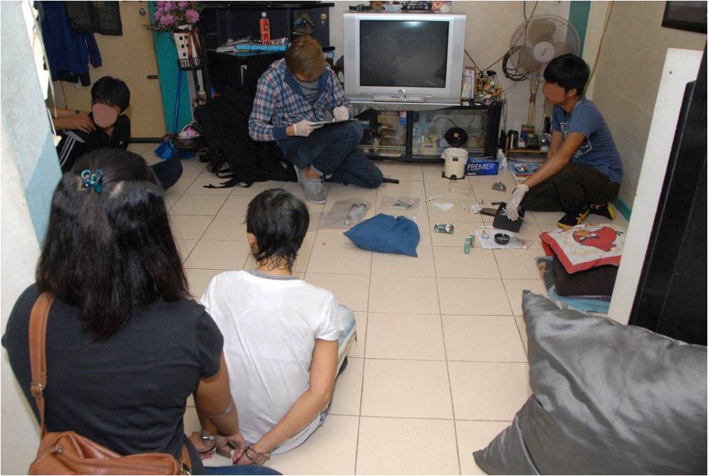 Photo 2: Suspects arrested by CNB officers during an operation. Also shown are the drug exhibits seized at the same location.