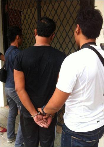 A suspect being arrested by CNB officers in an operation