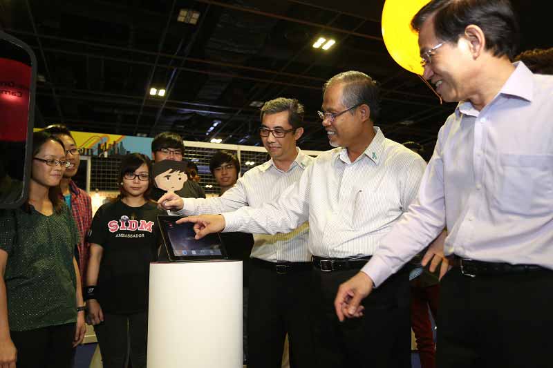 Mr Chan Lee Mun, Principal & CEO, Nanyang Polytechnic, Guest-of-Honour Minister Masagos Prime Minister’s Office and Second Minister for Home Affairs and Foreign Affairs and Mr Ng Ser Song, Director, Central Narcotics Bureau trying out the mobile game application