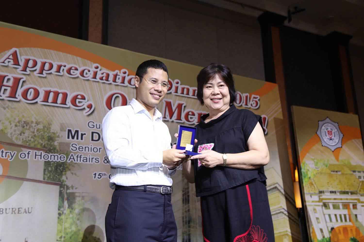 Photo 3: Senior Minister of State for Home Affairs and National Development, Mr Desmond Lee, giving out an SG50 medallion to a CNB pioneer