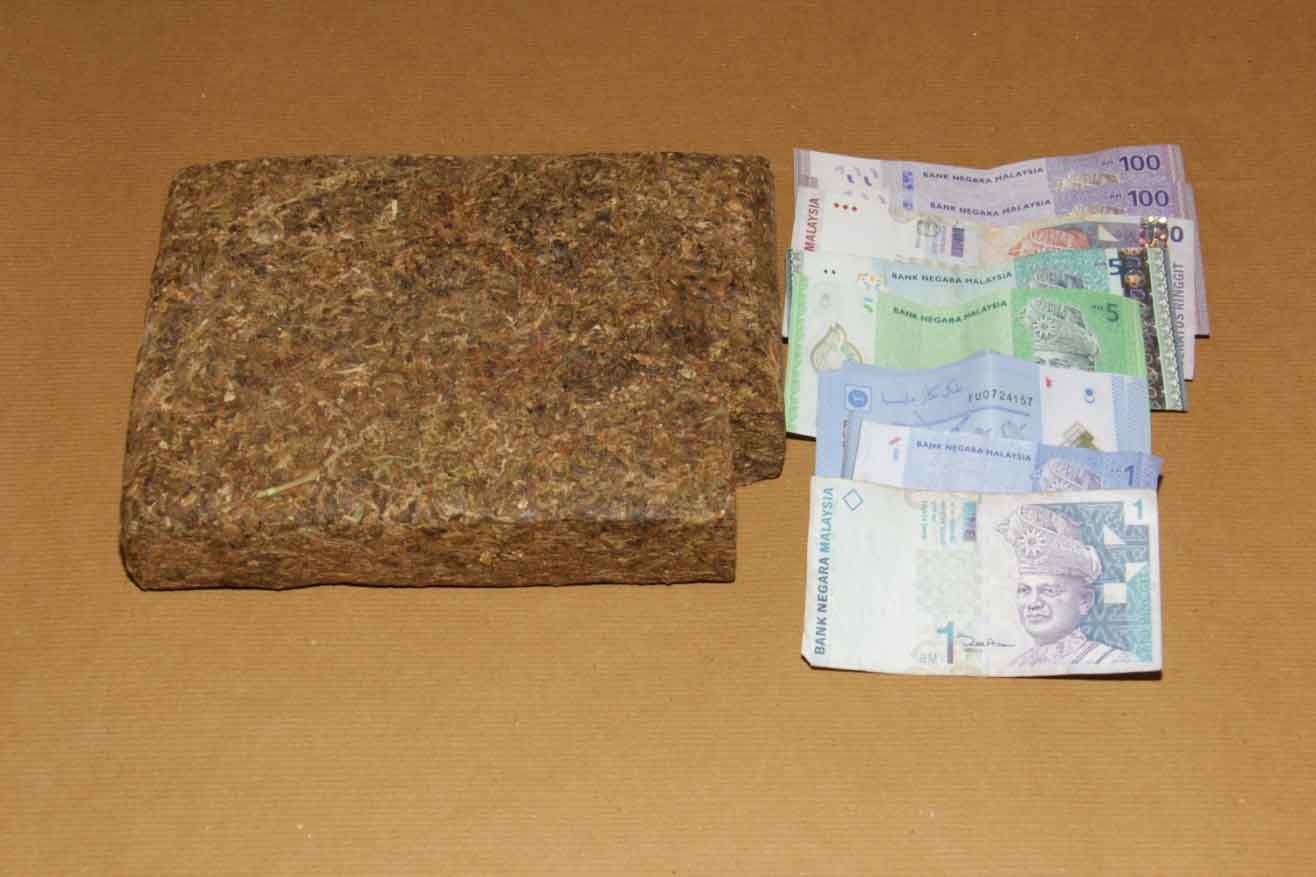 Photo 2: Block of cannabis and cash found in the van of the 35-year-old suspect Photo 2: Block of cannabis and cash found in the van of the 35-year-old suspect