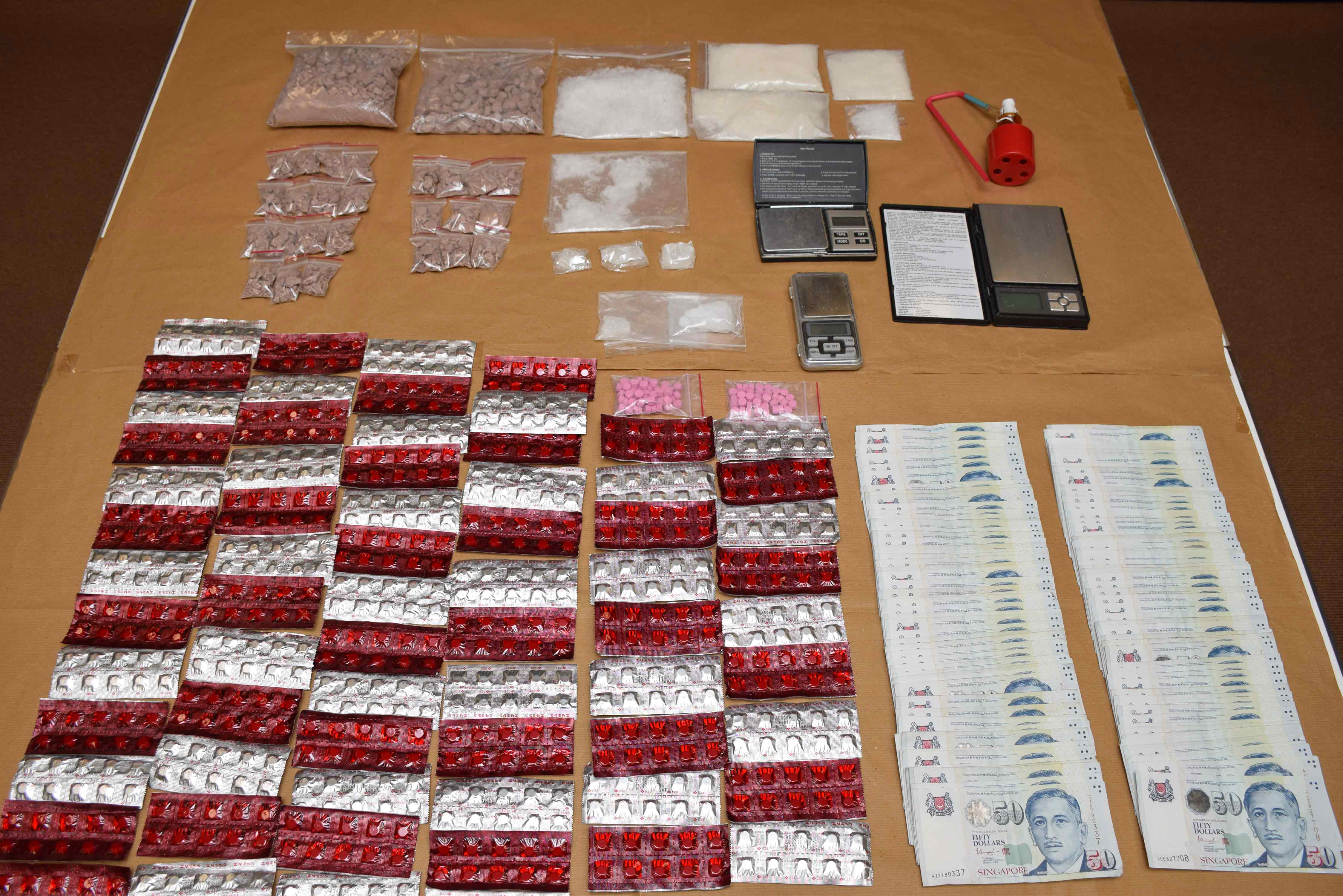 Photo 1: Drugs, drug paraphernalia and cash seized from CNB operation on 8 December 2015.