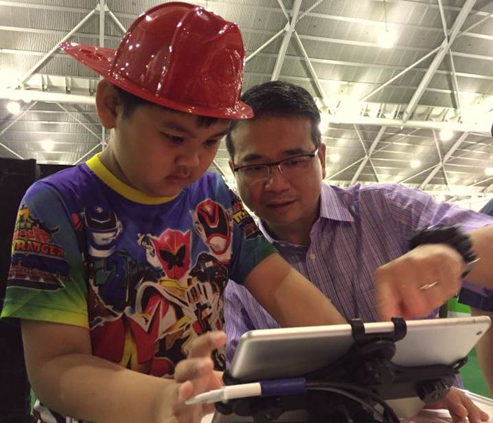 Mr Edwin Tong with a Home Team Festival visitor at the Preventive Drug Education booth