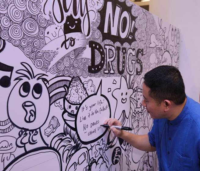 Photo-2: Parliamentary Secretary, Ministry of Home Affairs, Mr Amrin Amin, putting in his best touches at the doodle board, at the anti-drug skit event at the Woodlands Regional Library, 28 August 2016. [Photo by Home Team News, Ministry of Home Affairs].