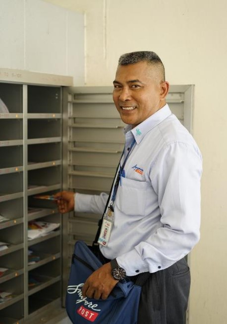 Staff of UADC partner, SingPost, distributing commemorative items to mail recipients.