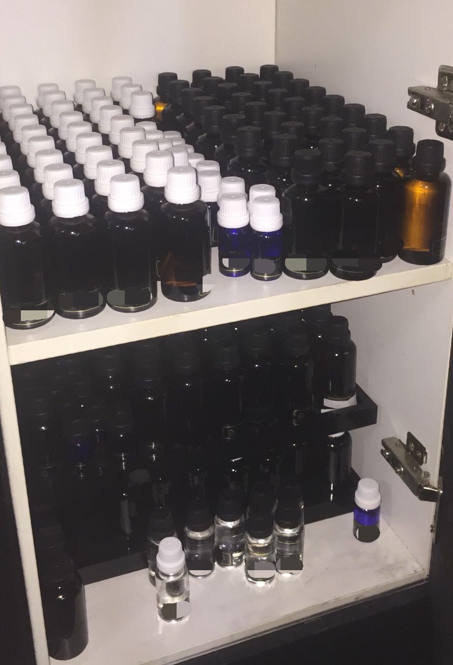 Photo-1: Cabinet with numerous glass bottles containing unknown liquid substances, recovered in CNB operation at Henderson Crescent on 12 March 2018.