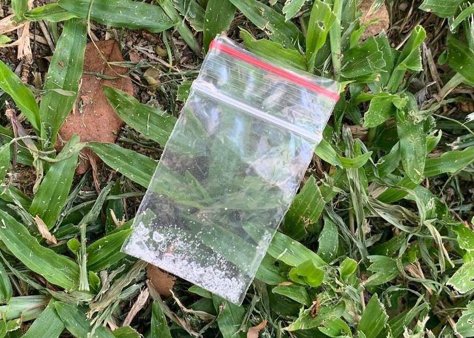 Photo-1 (CNB):  Small packet of ‘Ice’ found on grass patch, in CNB raid on a unit at Fajar Road on 11 September 2019.